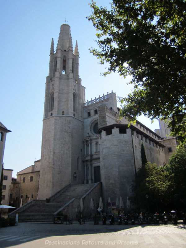 Stone basilica in Girona with large stairway leading to entrance and a a tower on the left