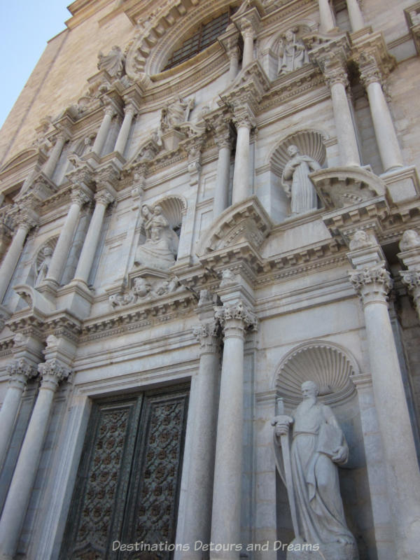 Up close view of statues in niches carved into the front of the Girona Cathedral