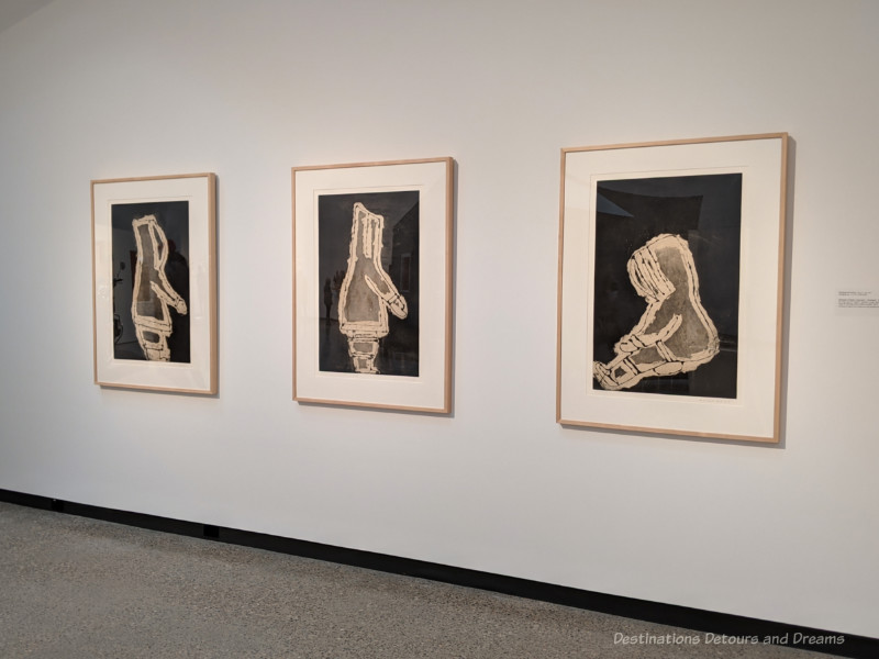 Three sugar-lift etchings showing Inuit figures in parka on display at Qaymajuq