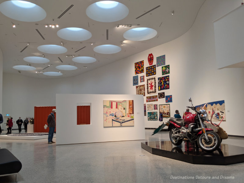 Two story skylight art gallery with white walls and ceiling displaying Inuit art