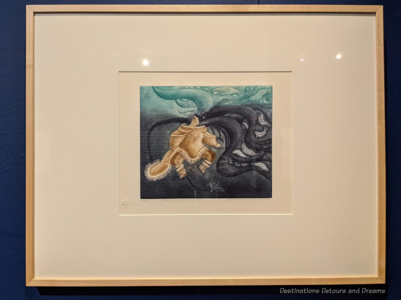 WAG Sedna Painting Painting of a figure in seal skin under swirls of black and teal water tells a story about the Inuit sea spirit
