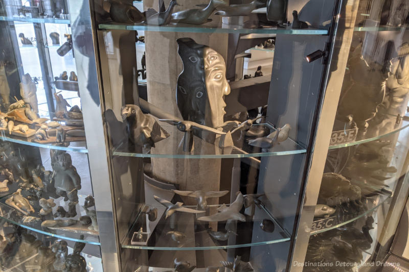 Three story visible vault with glass walls and shelves containing Inuit sculptures 