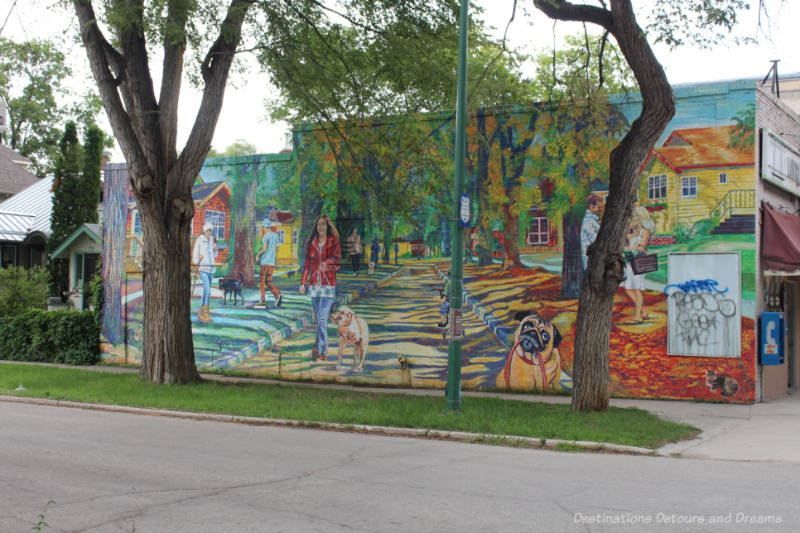 Mural on the side of a building showing life across the seasons in the Wolseley neighbourhood of Winnipeg