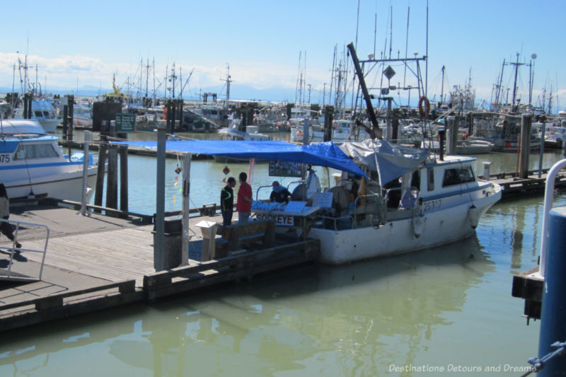 Fishing boat docked at boardwalk selling fresh fish in Steveston, British Columbia