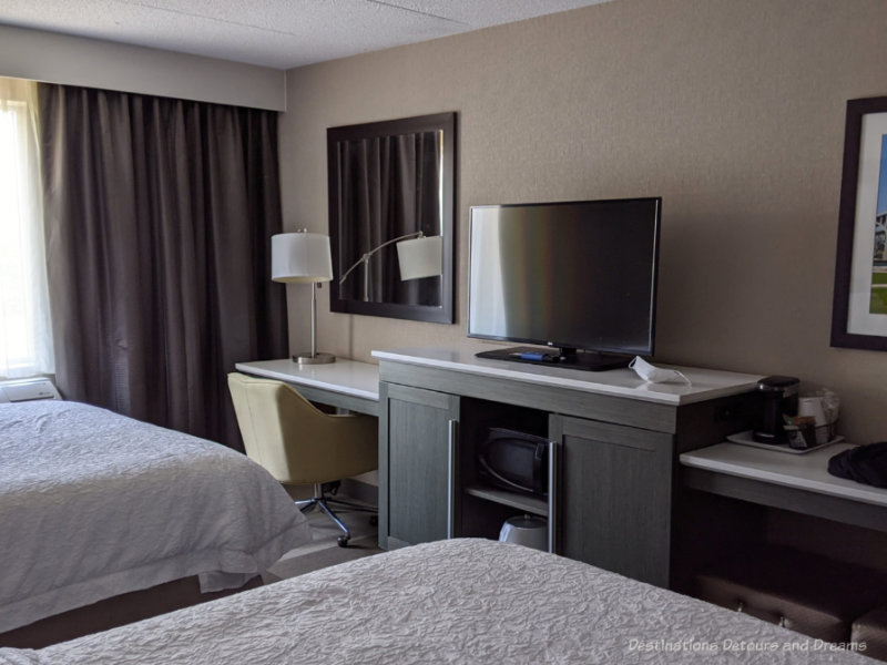 Hotel room showing two beds, desk, and TV stand