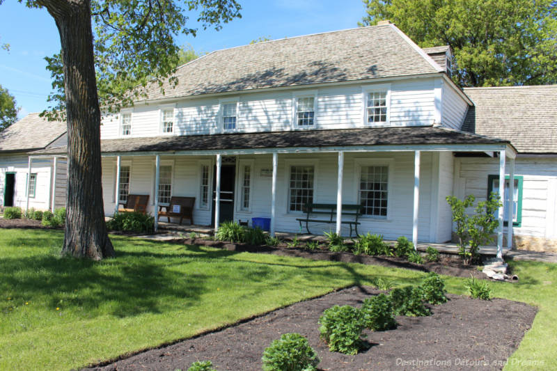 White wood house with front verandah that is now a house museum: Seven Oaks House