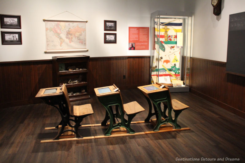 Old-fashioned school desks lined up in a museum school room display