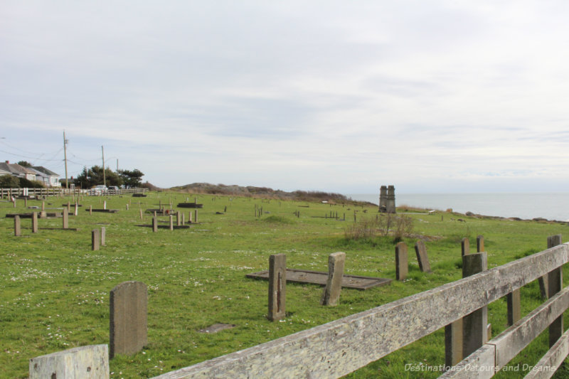 Cemetery with weathered gravestones on a hill overlooking the water