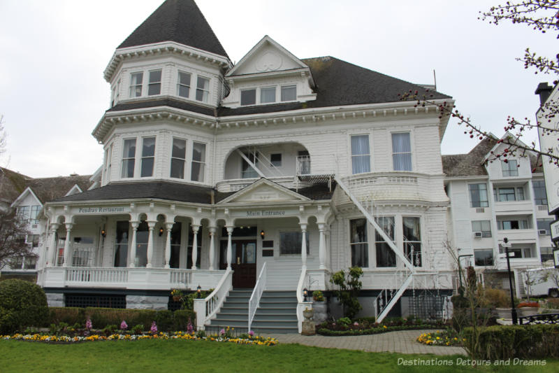 Victorian era three-story white mansion with large veranda now an inn and tea house