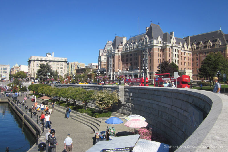 People along the Inner Harbour in Victoria, British Columbia, with a view of the Empress Hotel at the side