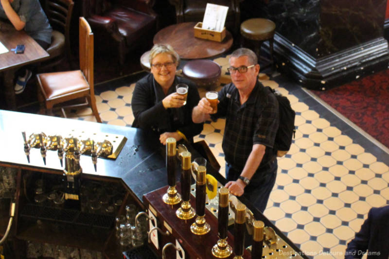 Man and woman raising a half-pint inside The OId Bank of England pub