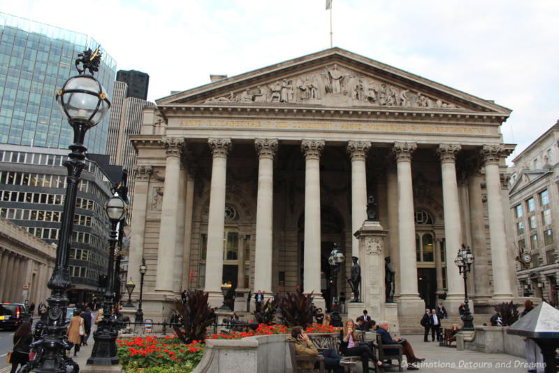 Neoclassical front of the Royal Exchange building with 8 round pillars at entrance and pediment sculptures