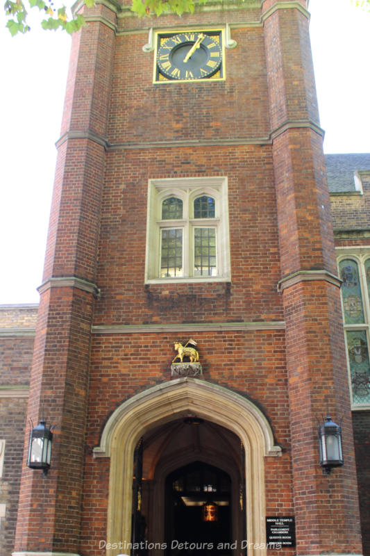 Red brick entrance tower to Inn of the Courts Middle Temple Hall with second floor window and gold horse figurine about arched doorway 