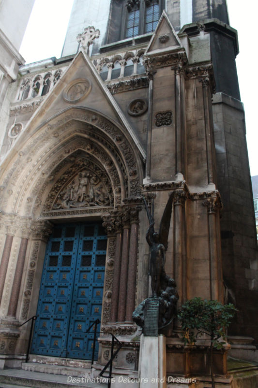 Blue door recessed into ornate stone archway of St Michael Cornhill Church