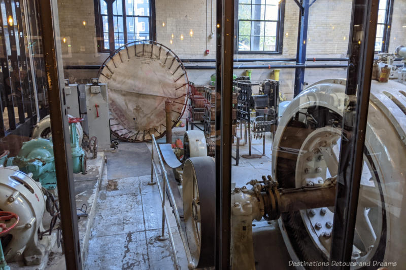 Century-old pumping station equipment behind glass walls at James Avenue Pumphouse Food and Drink