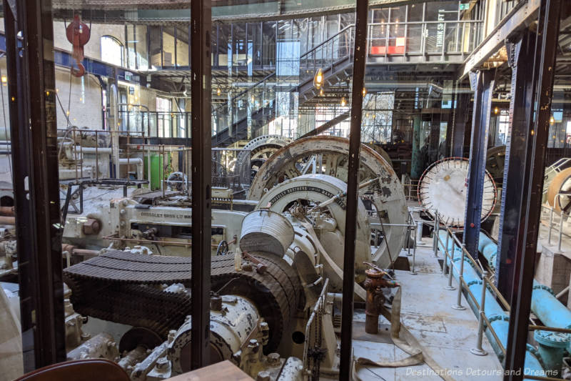 Century-old pumping station equipment behind glass walls at James Avenue Pumphouse Food and Drink