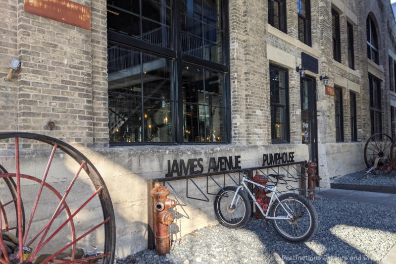 Historic building with brick exterior and large black-framed windows; James Avenue Pumphouse in Winnipeg