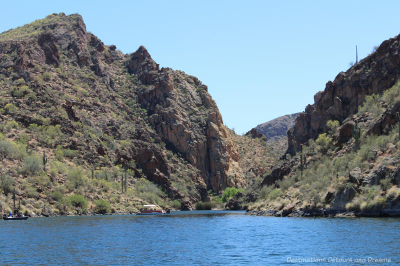 Blue lake leading into crevice between desert mountains