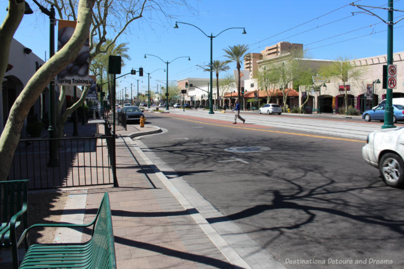 Wide street with wide sidewalks with benches and historical and low-rise buildings in downtown Mesa
