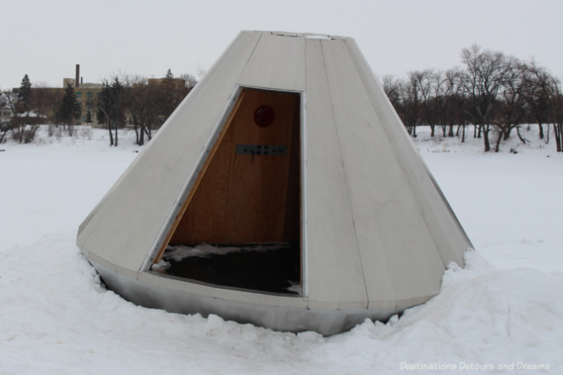 A white warming hut in the snow resembles a space capsule