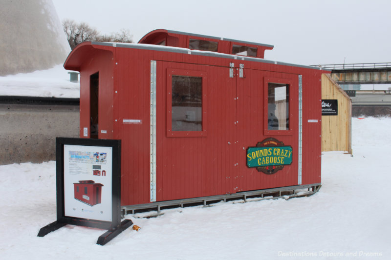 A red caboose-like structure built as a warming hut on the frozen river in Winnipeg, Manitoba 