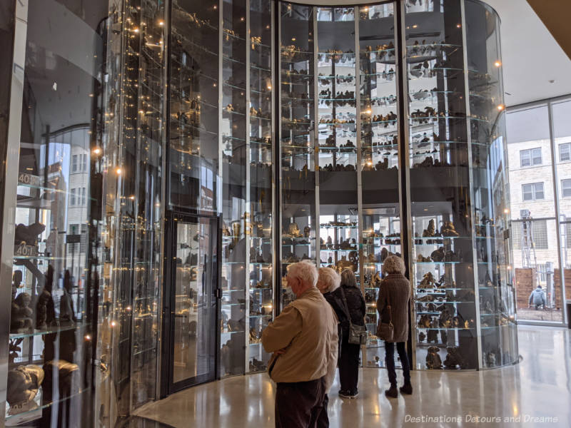 Three-story glass-walled visible vault holding Inuit art sculpture at Qaumajuq