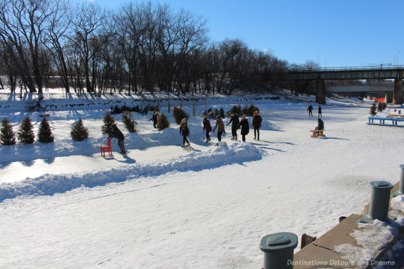 People ice skating on the Nestaweya frozen river trail in Winnipeg Manitoba