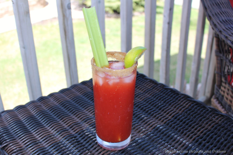 Caesar Cocktail A glass containing a Caesar cocktail with a stalk of celery and a slice of lime
