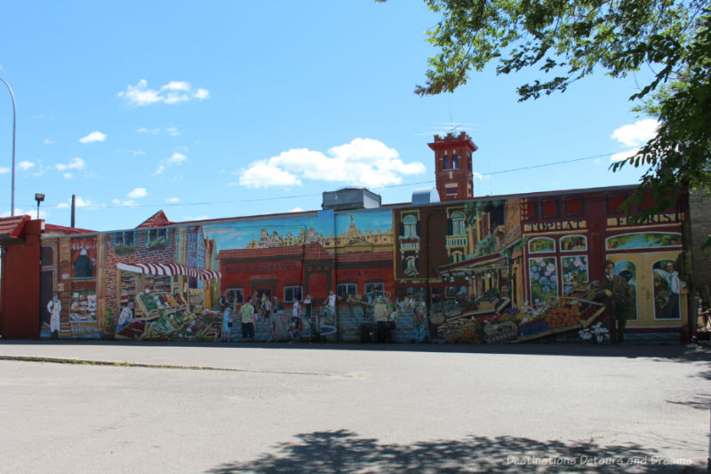 Mural of a European market square painted on the side of Winnipeg meat market