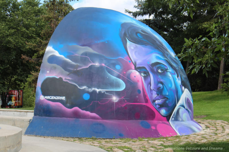 Mural by Mr Cenz in shades of blue and dark pink of a Winnipeg skateboarding icon