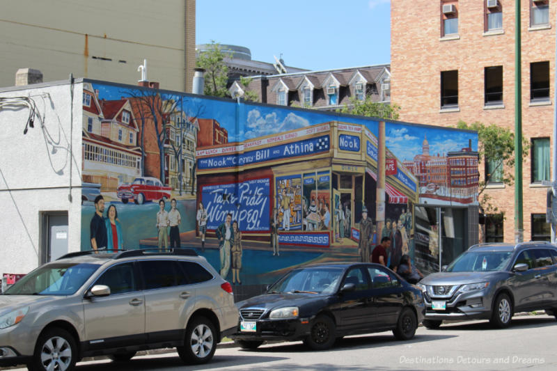 Mural painted on the side of a Winnipeg diner shows people entering the diner, eating at a table through a window, and other buildings in the background