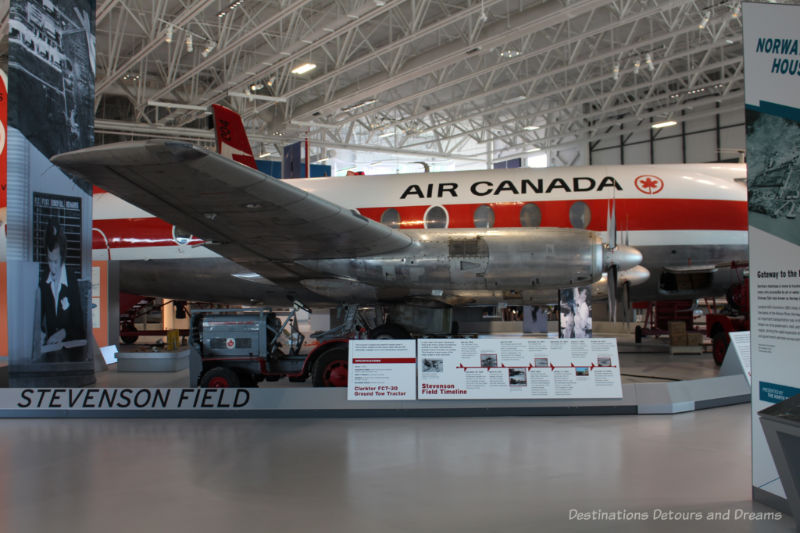 Royal Aviation Museum of Western Canada display about the history of Stevenson Field with an Air Canada plane in the background