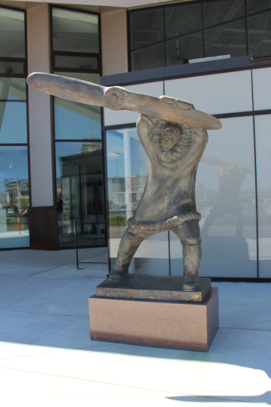 A bronze sculpture of  Tom Lamb in a fur-trimmer parka holding a propeller blade