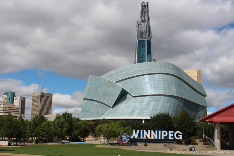View of the Canadian Museum for Human Rights and the Winnipeg sign from the CN Stage and Field at The Forks