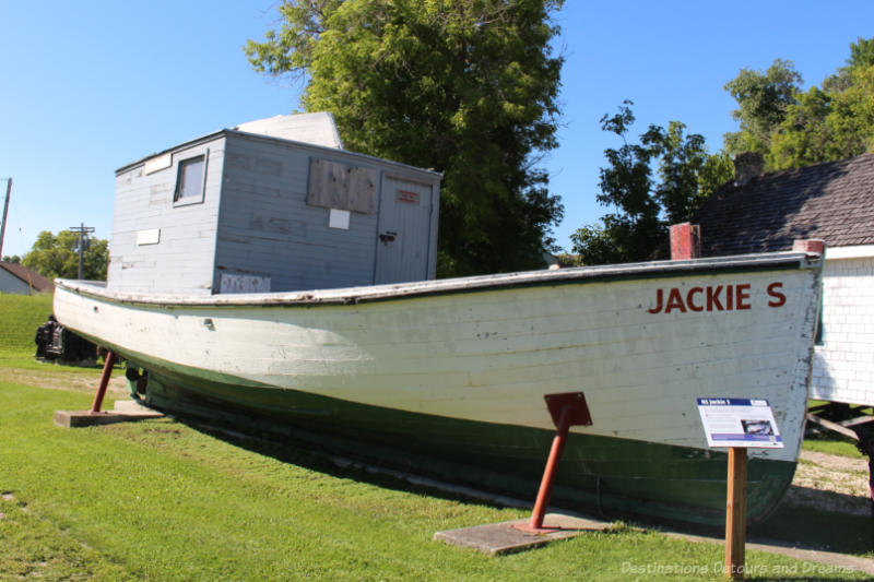 Wooden whitefish boat sitting on a grassy area