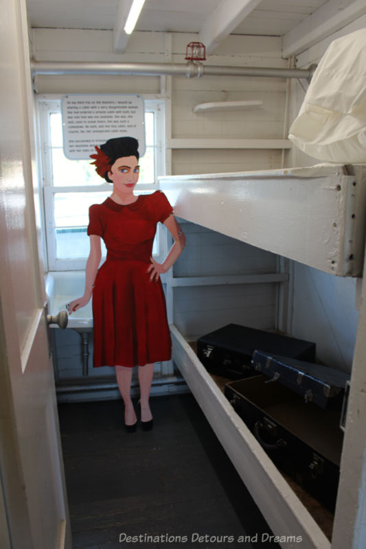 Cardboard women in red in a museum steamship cabin