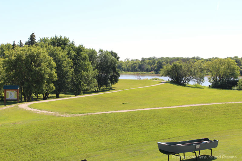 Grassy expense along the river with treed area in background at Selkirk Park