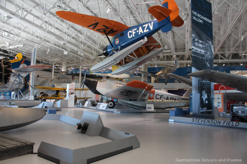 Heritage planes on display on the ground and suspended from the ceiling at the Royal Aviation Museum of Western Canada