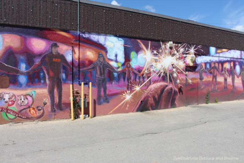 Mural depicting a traditional community round dance at a winter festival