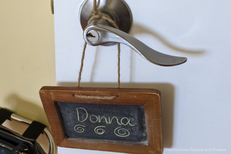 Small chalkboard with the name Donna hanging on a door knob of a bedroom door at Moon Gate Guest House