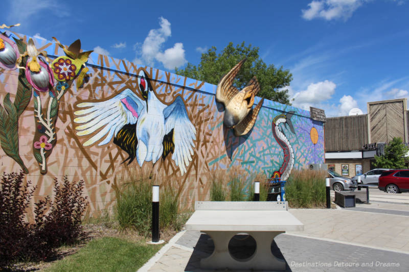 Mural on the side of a building with a couple of raised 3-D items shows a number of endangered species