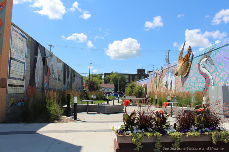 Park-like setting of a lane off Manitoba Avenue in Selkirk with plants, seating, and murals