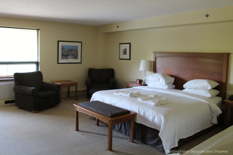 Photo of a king bed and two arm chairs in a suite at Temple Gardens Hotel & Spa