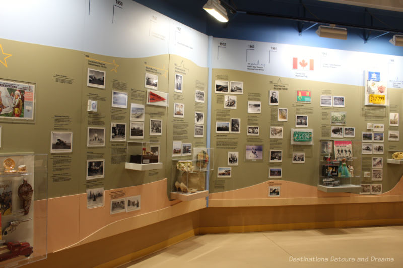 A timeline wall in a museum contains textual information, photos, and assorted relics