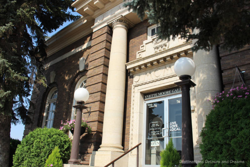 Historic brick building white columns on either side of entrance and large curved top windows