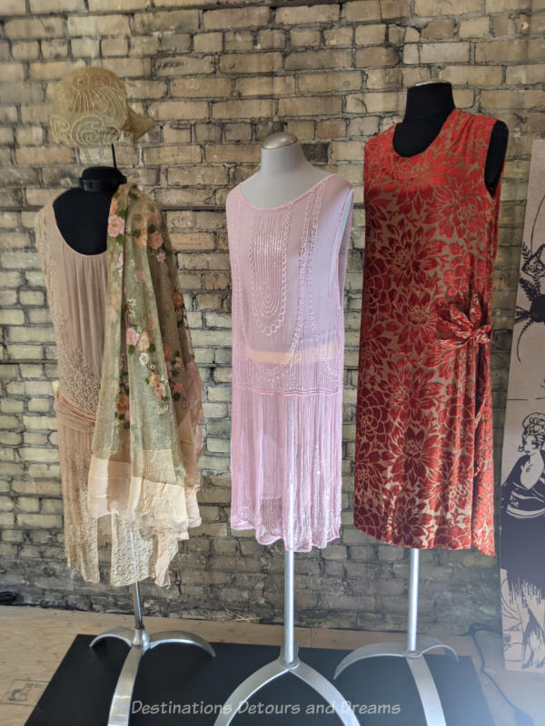Three flapper dresses on stick mannequins at a costume exhibit