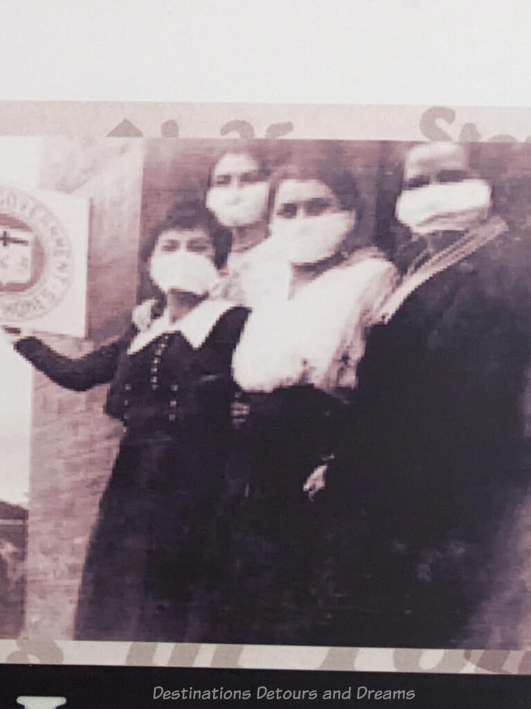 Old black and white photo showing women during the Spanish flu pandemic wearing white gauze face masks