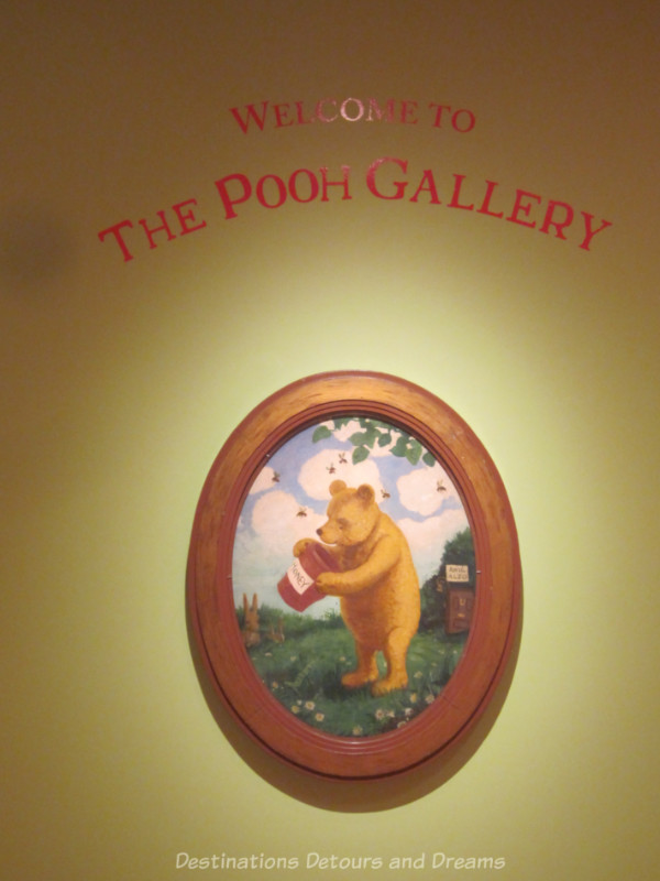 Oval framed photograph of Winnie-the-Pooh and his honey pot underneath a sign saying Welcome To The Pooh Gallery