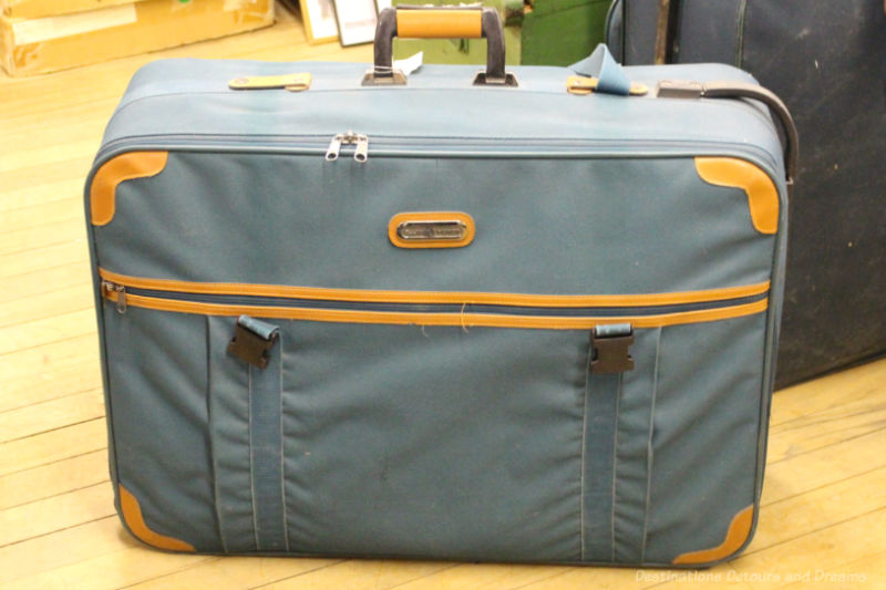 Soft-sided grey-blue zippered suitcase with orange trim