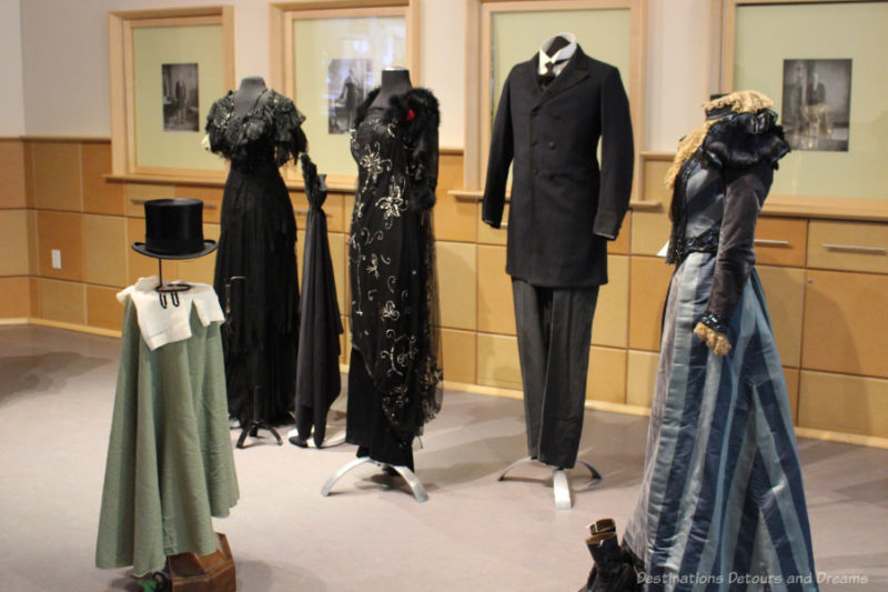 A collection of turn-of-the-twentieth-century evening wear display on headless mannequins at a Costume Museum of Canada exhibit